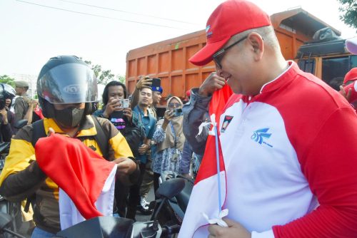 Pj Wako Andree Algamar melakukan pembagian bendera Merah Putih saat Pencanangan Gerakan Nasional Pembagian 10 Juta Bendera Merah Putih Tingkat Kota Padang yang dilaksanakan Rabu (31/7) pagi, di depan Kantor Balai Kota Padang, Aie Pacah. Sebanyak 15.355 bendera merah putih dibagikan. (ist)
