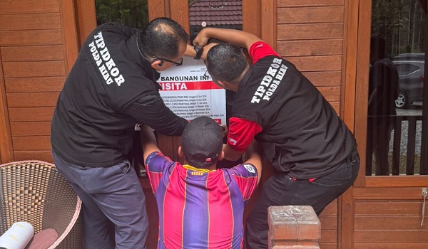 Tim Ditreskrimsus Polda Riau tengah memasang spanduk penyegelan di salah satu homestay di Harau, Sumatera Barat.(ist)