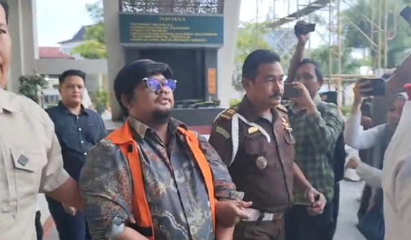 Bendahara PMI Riau, Rambun Pamenan terlihat menggunakan baju tahanan dan tangan diborgol di Kejati Riau, Senin (9/12/2024).(ist)