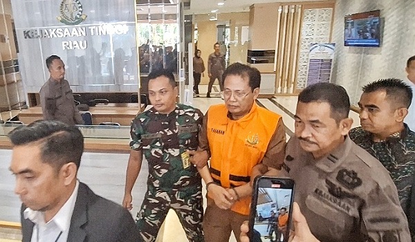 Datuk Syahril Abu Bakar, mantan Ketua Palang Merah Indonesia (PMI) Provinsi Riau menggunakan rompi oranye saat keluar dari Kejati Riau.(ist)