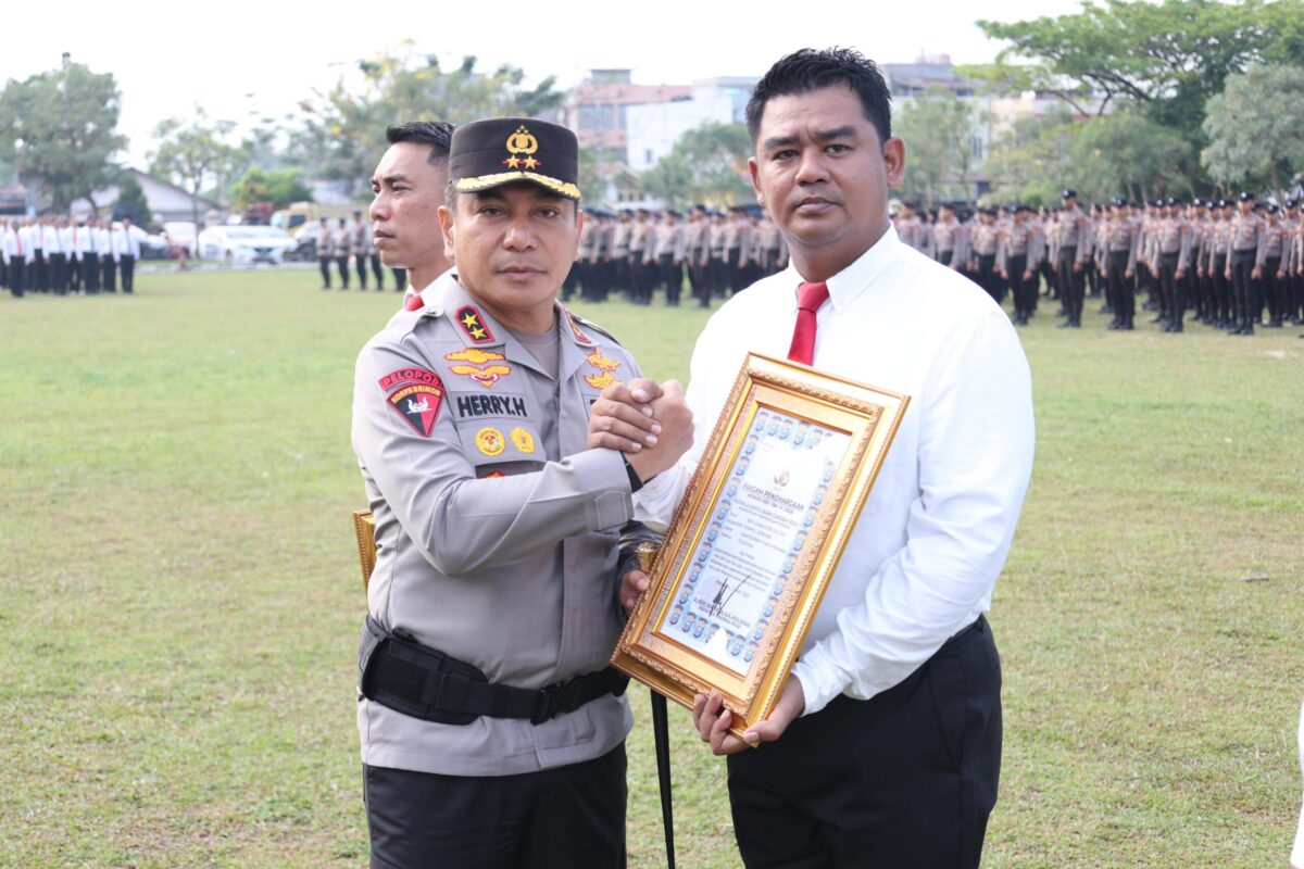 Kompol Bery Juana Putra (kanan) saat terima penghargaan dari Kapolda Riau Irjen Pol Herry Heryawan di Mapolda Riau.(Ist)