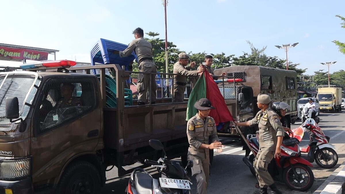 Petugas Satpol PP membawa kursi dan meja milik PKL yang melanggar aturan jam jualan di depan Lapau Panjang Cimpago, Padang, Sabtu (14/6/2025). Penertiban dilakukan karena pedagang tetap beroperasi di luar waktu yang ditetapkan pemerintah kota. (Foto: Istimewa)