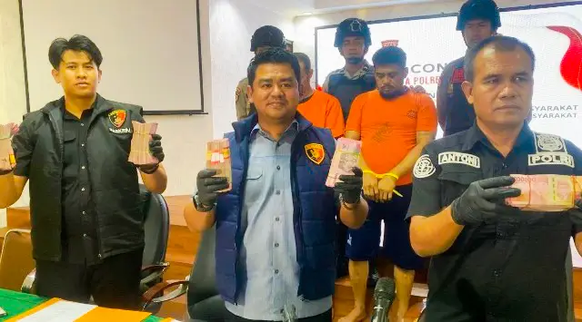 Polisi menunjukkan barang bukti uang tunai Rp356 juta hasil curian dari brankas Kantor Pos Pekanbaru. (Ist)