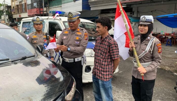 Meriahkan HUT RI ke-80, Satlantas Pekanbaru Berbagi Bendera Merah Putih di Jalan Juanda Pekanbaru