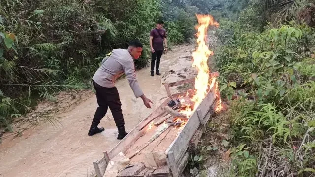 Petugas memusnahkan satu unit meja kerja PETI dengan cara dibakar di lokasi penambangan ilegal di Rengat Barat. (Ist)