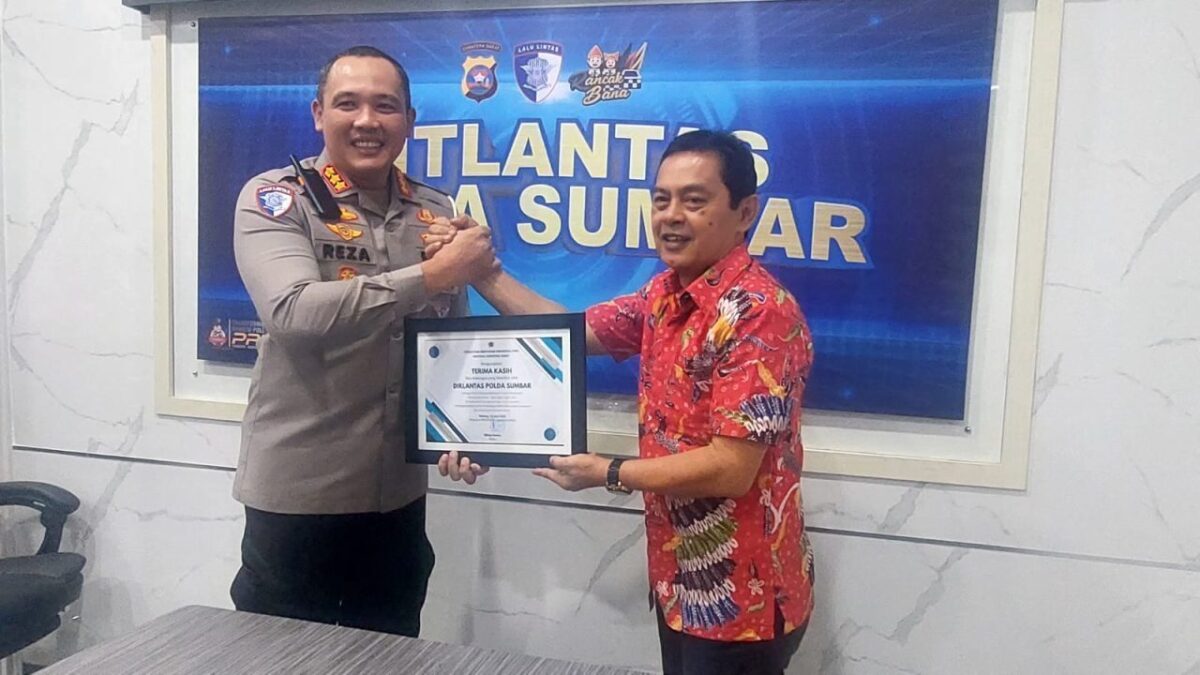 Ketua PWI Sumbar Widya Navies menyerahkan apresiasi kepada Dirlantas Polda Sumbar, Kombes Pol Reza, sebagai bentuk penghargaan. (ist)